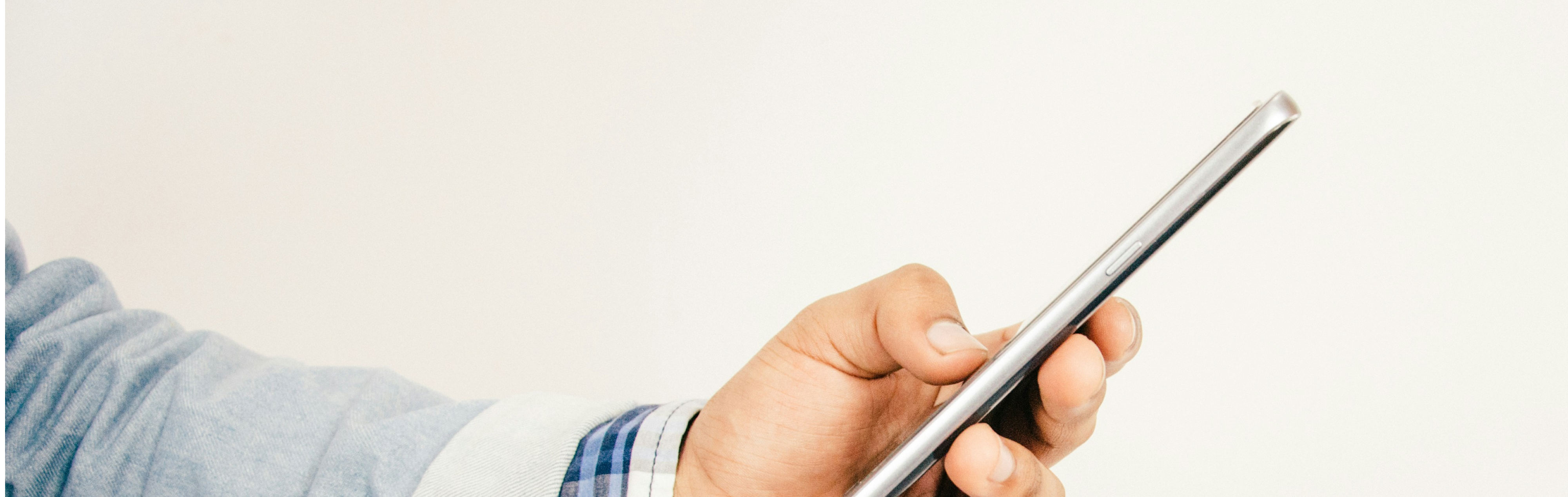 Homem a segurar smartphone na mão enquanto consulta a aplicação móvel gov.pt