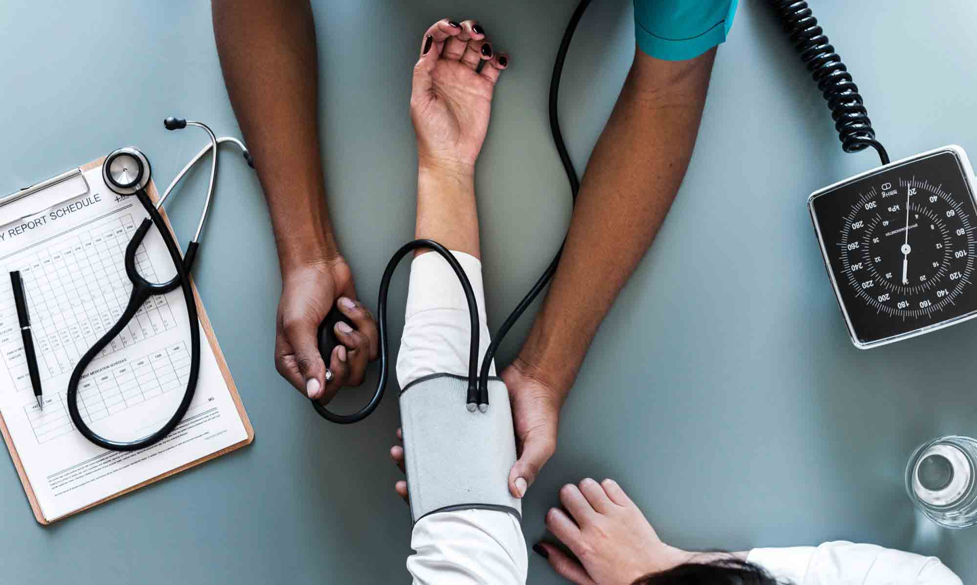 médico a medir tensão arterial a paciente